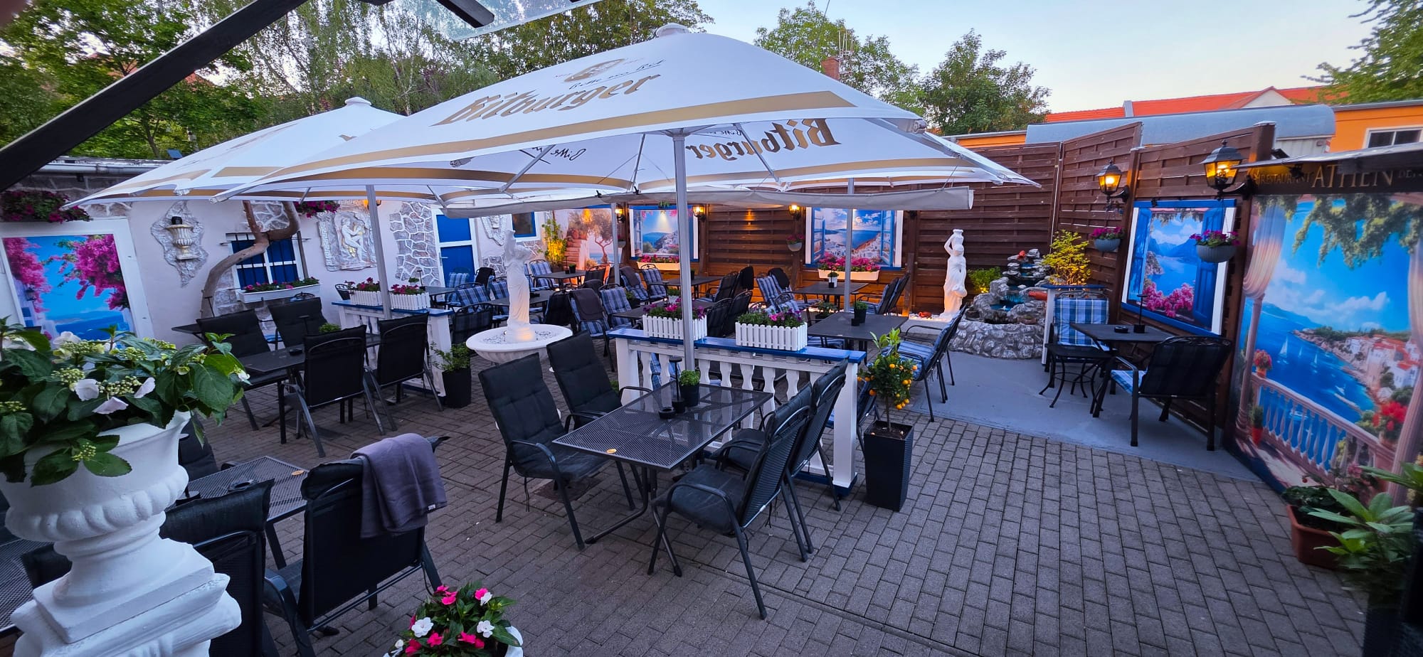 Biergarten mit Sonnenschirmen und griechischem Flair